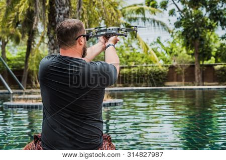 A Sympathetic Man Launches A Drone For Flight, With Which You Can Take Photos And Videos, Near The S