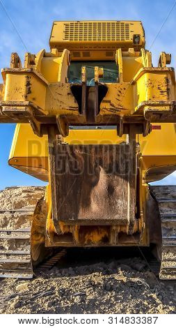 Vertical Heavy Duty Construction Vehicle With Peeling Yellow Paint And Dirty Metal Tracks
