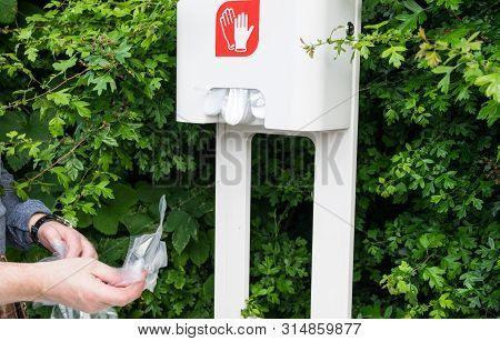 The Man With Two Hands Take Cellophane Gloves On The Gas Station.