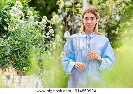 Young And Attractive Woman Drinking Sparkling Water From Glass Eco Biodegradable Bottle At Modern Pa