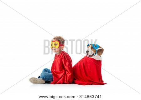Preschooler Child And Beagle Dog In Masks And Red Hero Cloacks Sitting Back To Back Isolated On Whit