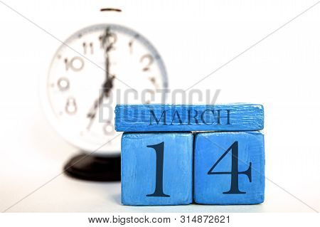 March 14th. Day 14 Of Month, Handmade Wood Calendar And Alarm Clock On Blue Color. Spring Month, Day