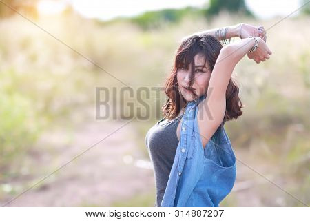 Young And Cute Girl Having A Happy Time And Enoying Amoung Grass Field In Nature