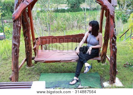 Portrait Of Beautiful And Cute Asian Woman Sitting And Relaxing In Nature
