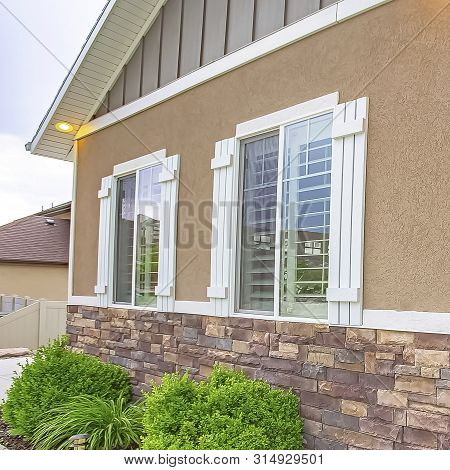Square Frame Exterior View Of Home With Paved Path Leading To The Front Door With Sidelight