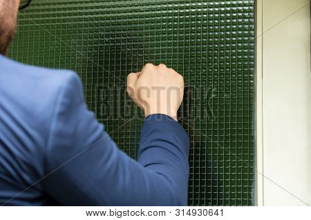 Man Standing At The Entrance Of The House Knocking The Door
