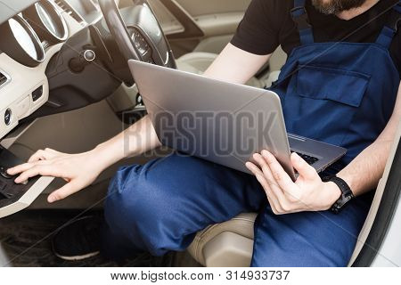 Professional Car Mechanic Working In Auto Repair Service. Computer Video Investigate. Engine Diagnos