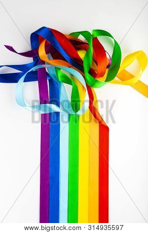 Lgbt Flag Symbol Made Of Satin Ribbons On A White Background. A Rainbow Of Ribbons Mixes With Each O