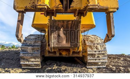 Panorama Frame Heavy Duty Construction Vehicle With Peeling Yellow Paint And Dirty Metal Tracks