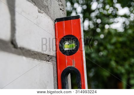 Checking The Level Of Brick Wall With Waterpas