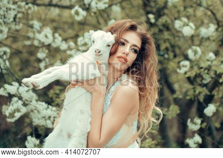 Woman With Goat In Blossom Forest. Nymph In A Blossom Forest With Lamb. Beautiful Girl, Sensual Youn