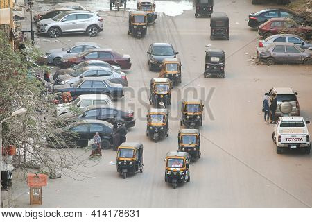 Giza, Egypt - January 26, 2021: View Of The City Street Full Of Auto Rickshaws Bajaj Re.
