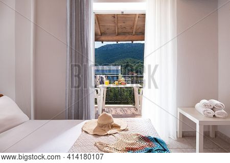 Closeup Of Open Door To Summer View Balcony With Terrace Furniture, Wooden Roof Ceiling, White Inter