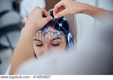 Qualified Neurophysiologist Placing The Electrodes On The Female Scalp