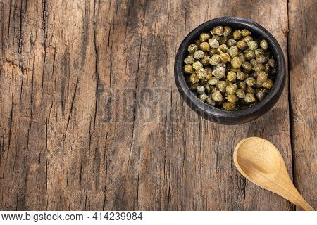 Capers In Wooden Bowl - Capparis Spinosa. Wood Background