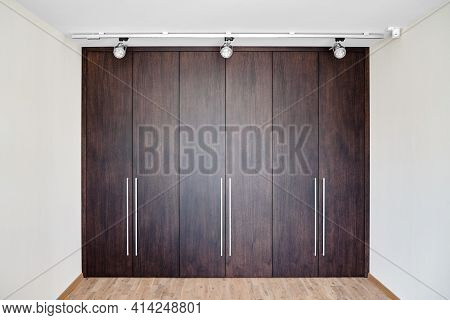Wardrobe Of Dark Oak Veneer In Minimal Style In Light Room