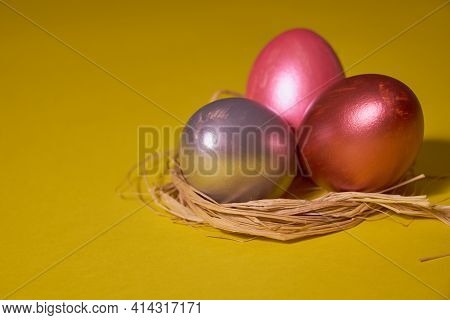 Pearl Colored Eggs In The Nest On A Yellow Background. Easter Concept.