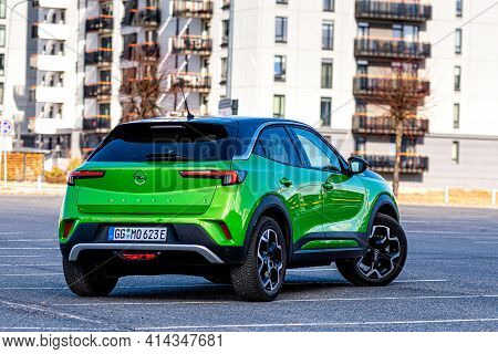 Riga, Latvia - 26 March, 2021: Green Electric Vehicle Opel Mokka-e In The Parking Lot On The Backgro