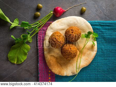Falafel dumplings served with khubus and rocket leaves. Beautiful photo of Falafil- a popular Middle Eastern street food. View from above.