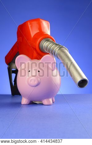 A Concept Of Saving Money At The Gas Pumps Using A Piggy Bank And Red Fuel Pump Over A Blue Backgrou