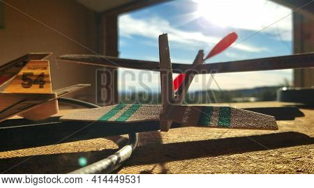 Balsa Wood Toy Airplane With Red Prop In Garage