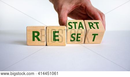 Reset And Restart Symbol. Businessman Hand Turns Cubes And Changes The Word 'reset' To 'restart'. Be