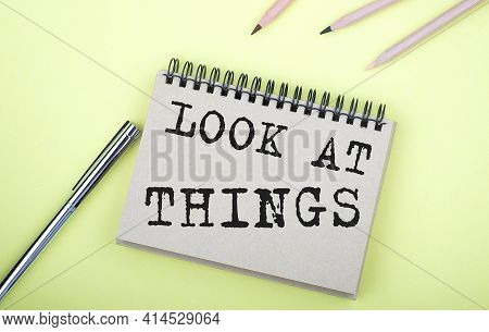 Look At Things Text On Notebook With Pen On Yellow Background
