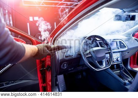 Car Service Worker Cleans Interiror With Steam Cleaner