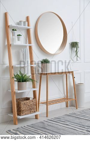 Console Table With Shelving Unit And Mirror On White Wall In Hallway. Interior Design