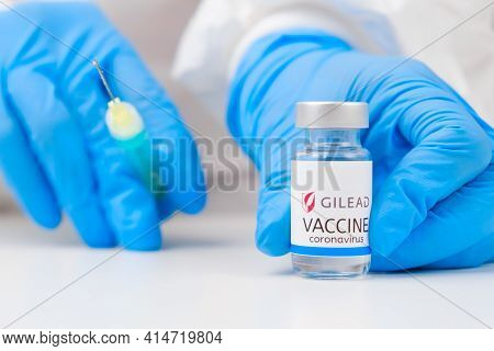 Gilead Vaccine Against Coronavirus And Syringe For Injection In Health Worker Hand In Rubber Gloves 