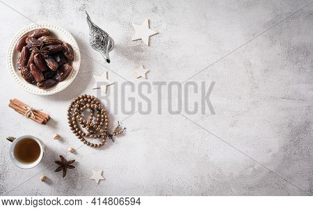 Ramadan Food And Drinks Concept. Ramadan Arabian Lamp, Wood Rosary, Tea, And Dates Fruit On Dark Sto