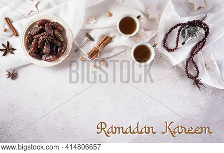 Ramadan Food And Drinks Concept. Ramadan Arabian Lamp, Wood Rosary, Tea, And Dates Fruit On Dark Sto