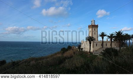 Phare Cap Spartel Light House On The Atlantic Of Morocco Near Tangier. Framed By Palm Trees And Bril