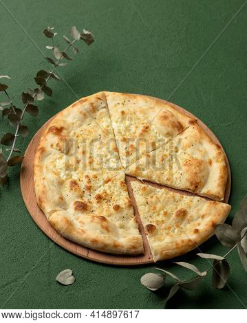 Cut Cheese Pizza With Melted Parmesan And Mozzarella On Green Background. Vertical Format 4x5 For Ad