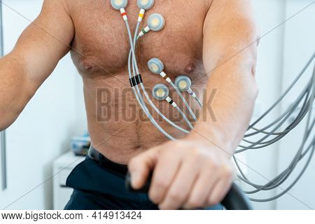 Patient on exercise bike with electrodes during ECG