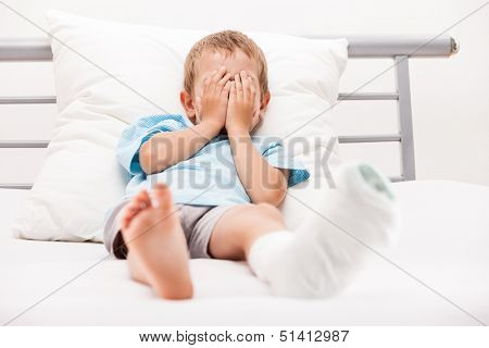 Human healthcare and medicine concept - little child boy with plaster bandage on leg heel fracture or broken foot bone