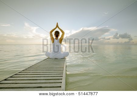 Caucasian woman practicing yoga at seashore