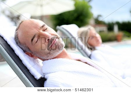 Senior man in spa hotel relaxing in long chair