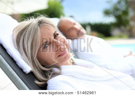 Senior woman in spa hotel relaxing by the pool