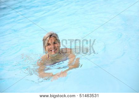 Cheerful senior woman in swimming-pool