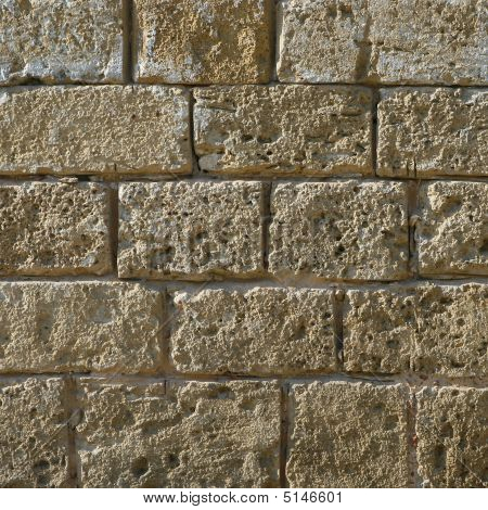 Fragment af sandfarvede sten mur