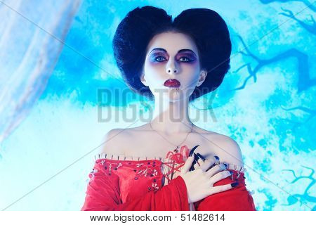 Portrait of a beautiful female vampire over moonlight background.