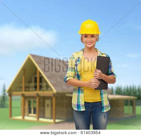 repair, construction and maintenance concept - smiling woman in helmet with clipboard
