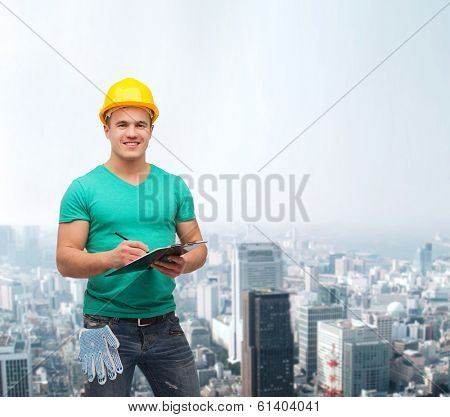 repair, construction and maintenance concept - smiling man in helmet with clipboard