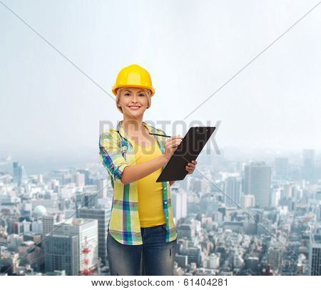 repair, construction and maintenance concept - smiling woman in helmet with clipboard