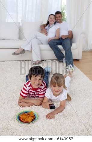 Crianças felizes assistindo televisão no chão na sala de estar
