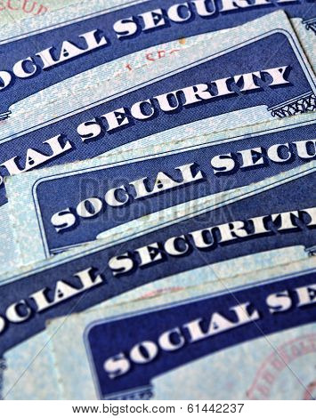 Closeup detail of several Social Security Cards representing finances and retirement