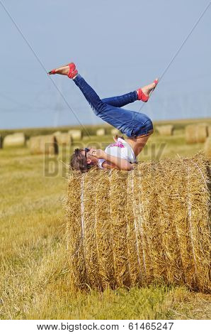 Young woman relaxing on hay bale