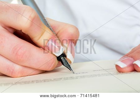 a woman signs a contract or a will with a fountain pen.