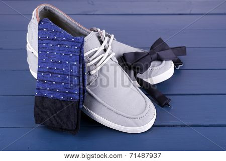 Top-Siders, socks and bow-tie on dark blue wooden background